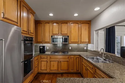 a kitchen with kitchen island granite countertop a sink stainless steel appliances and cabinets