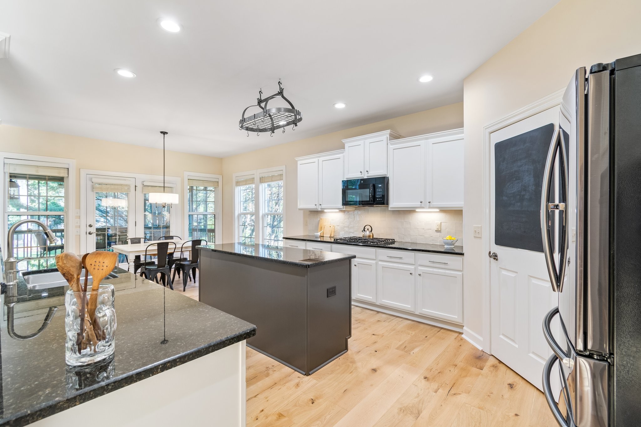 5028 Abington Ridge Lane Franklin, TN 37067 - Photo 22 of 68 a kitchen with stainless steel appliances granite countertop a refrigerator a sink dishwasher a stove and a dining table with wooden floor