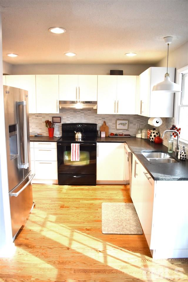6027 Epping Forest Drive Raleigh, NC 27613 - Photo 3 of 4 Gorgeous updated kitchen with new cabinets, leathered granite countertops, appliances and beautiful hardwood floors. Marble tile back splash adds a touch of class. This room has been opened up to the dining room! Tons of storage!