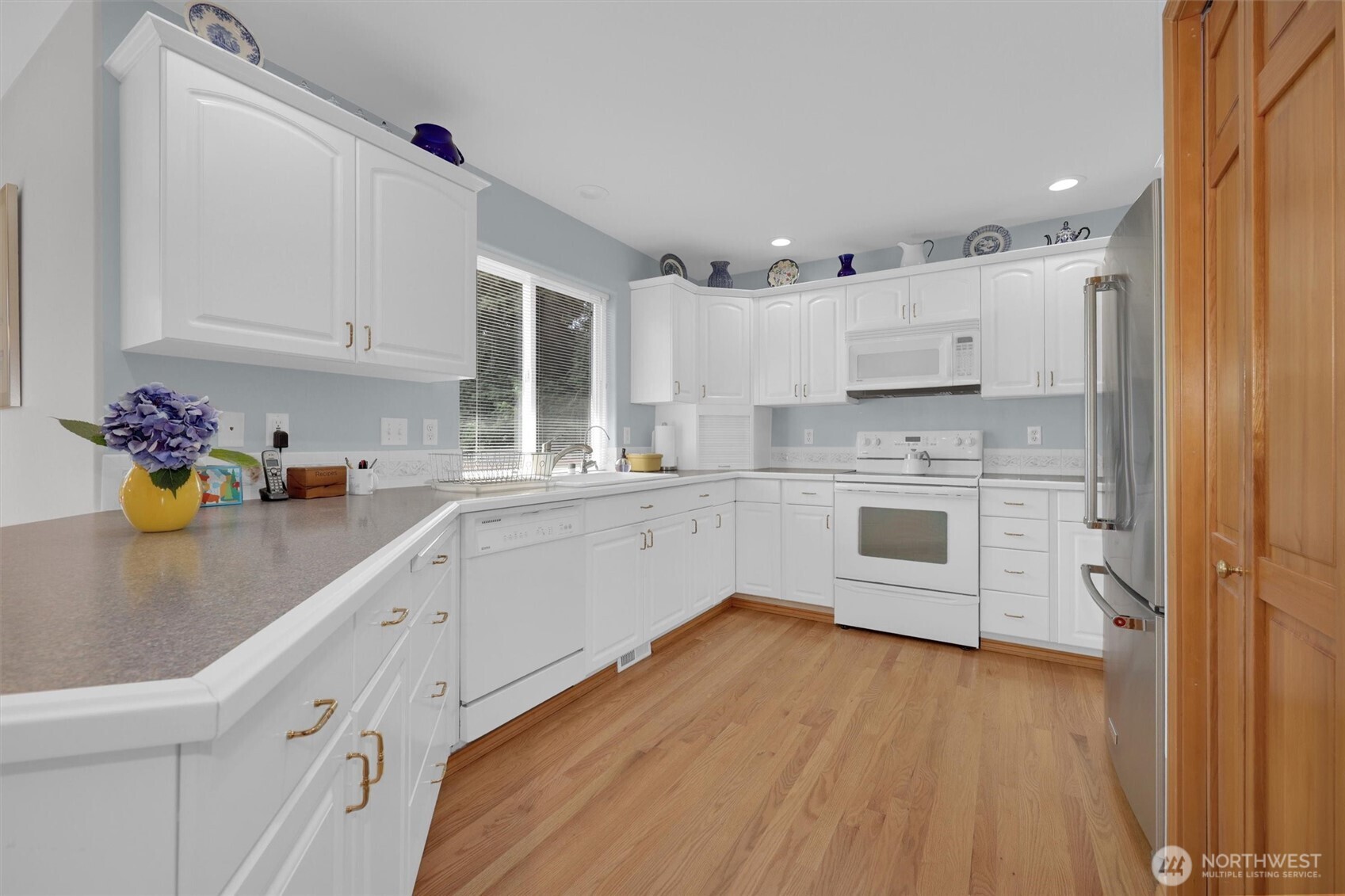 15403 Southeast 254th Street Covington, WA 98042 - Photo 5 of 22 a kitchen with cabinets a sink and wooden floor