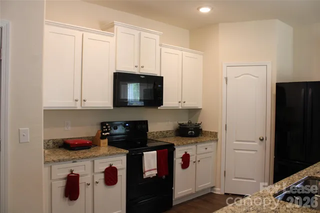 a kitchen with stainless steel appliances granite countertop a refrigerator a stove a microwave and cabinets