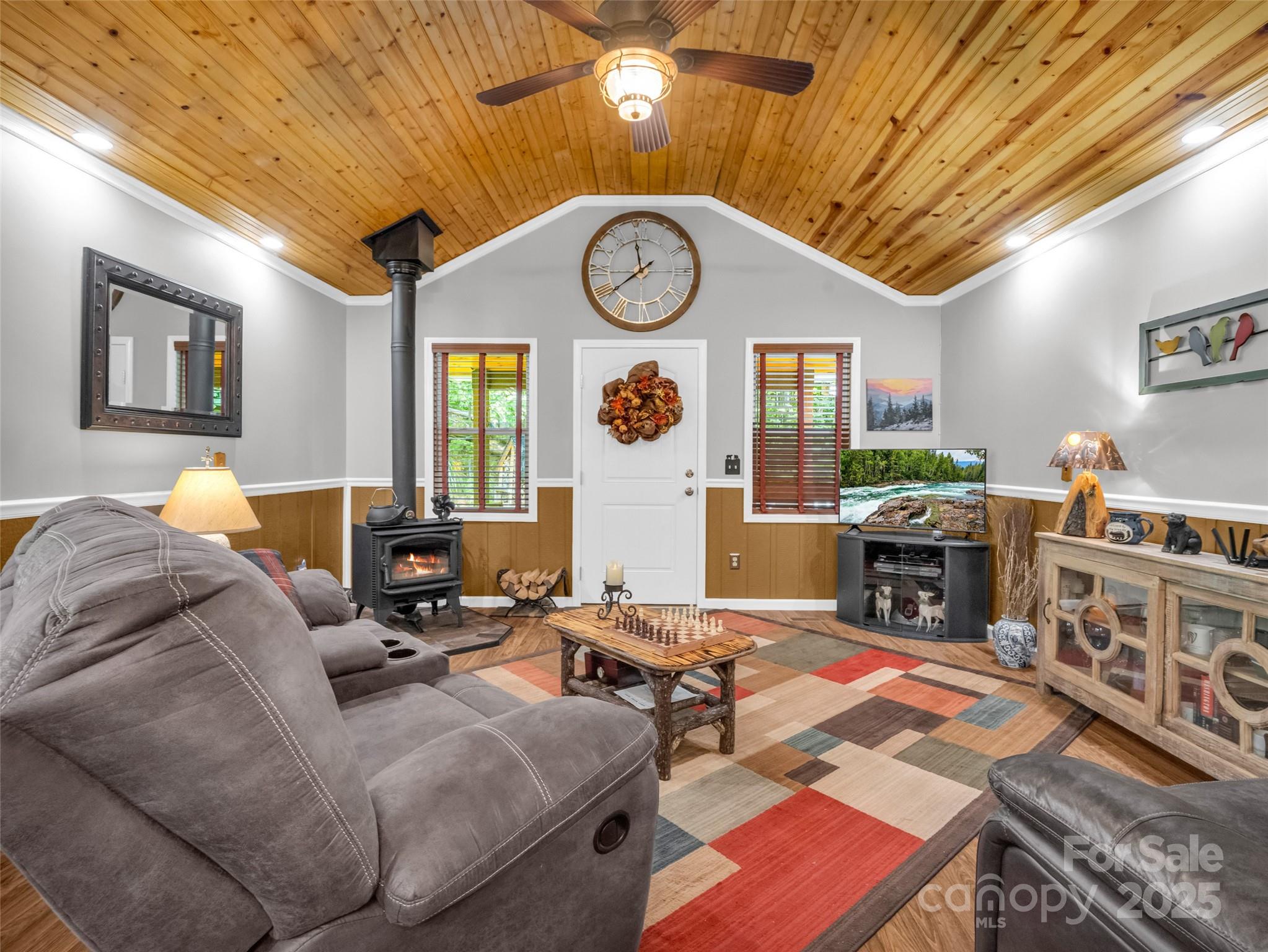 479 Camp Hill Road Mill Spring, NC 28756 - Photo 15 of 48 a living room with furniture a clock and a flat screen tv