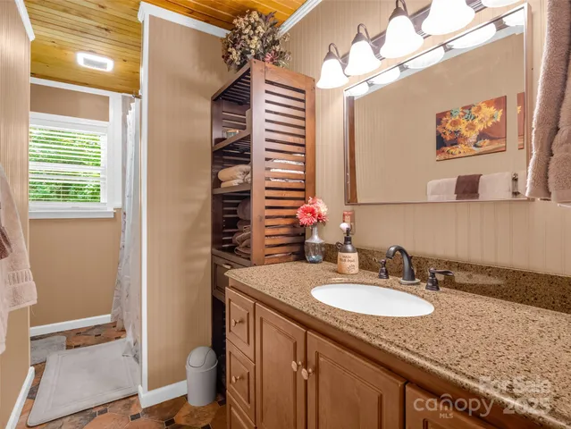 a bath room with a granite countertop sink and a mirror