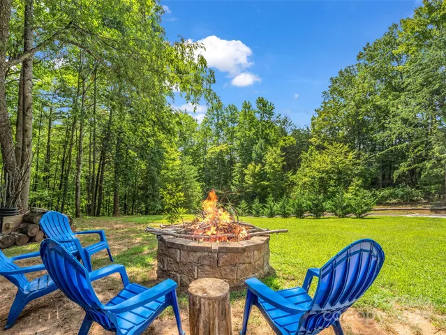 a view of a swimming pool with a lounge chair and a fire pit