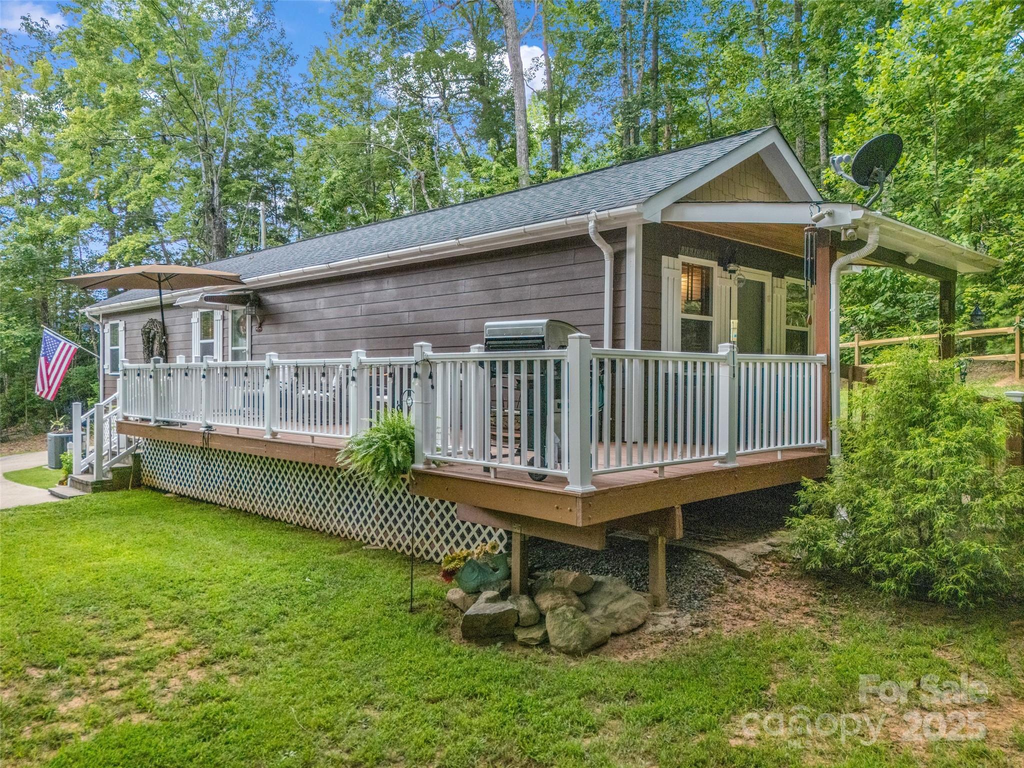 479 Camp Hill Road Mill Spring, NC 28756 - Photo 39 of 48 a backyard of a house with a garden and deck