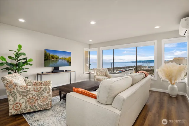a living room with furniture flat screen tv and a large window