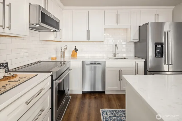a kitchen with stainless steel appliances and refrigerator