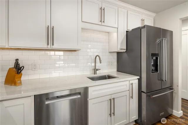 a view of a dining room with furniture a chandelier and large windows