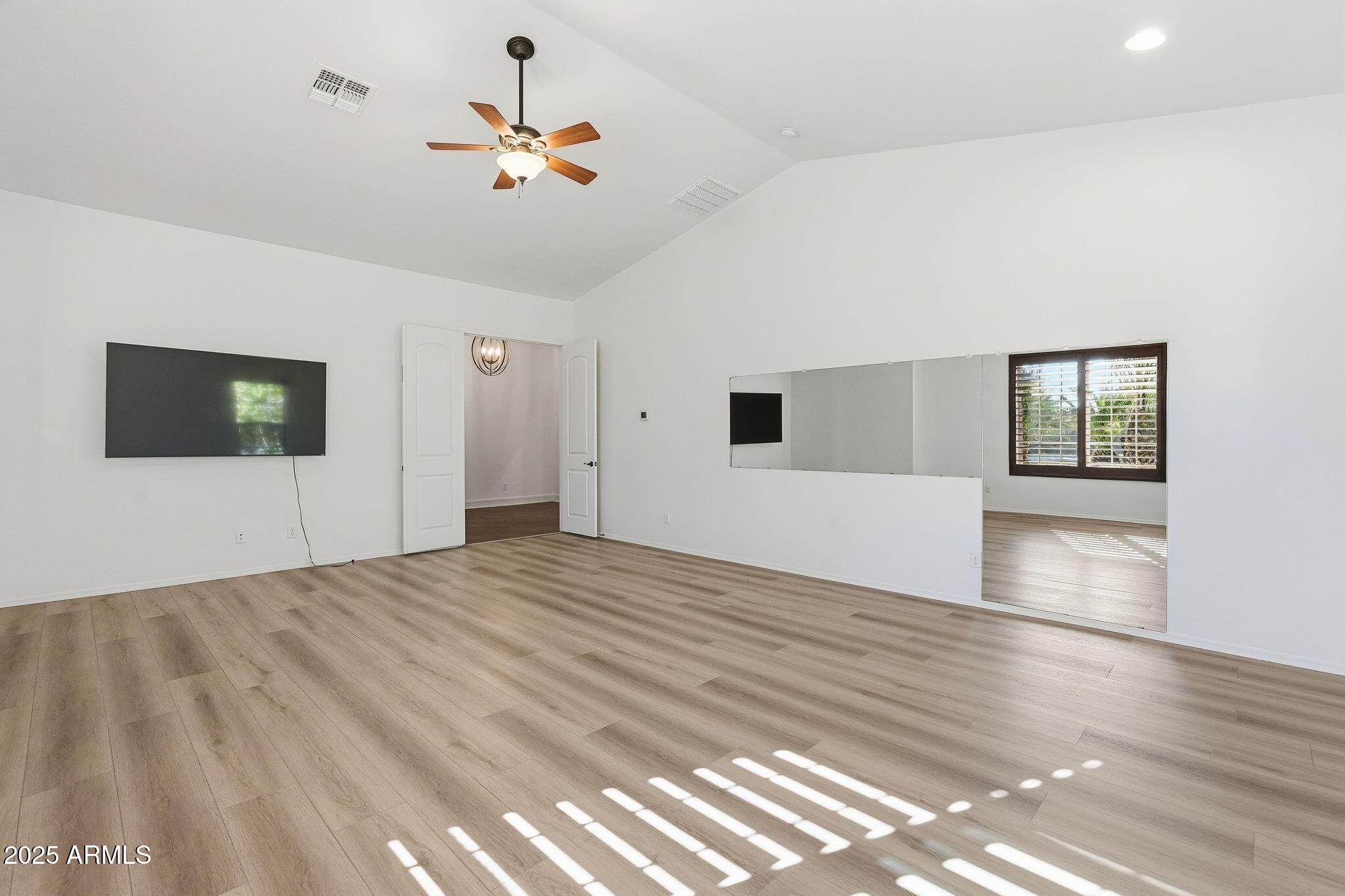 2218 East Brooks Farm Road Gilbert, AZ 85298 - Photo 35 of 55 a view of a livingroom with wooden floor and a ceiling fan