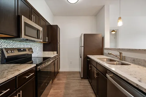 a kitchen with stainless steel appliances granite countertop a sink stove and refrigerator
