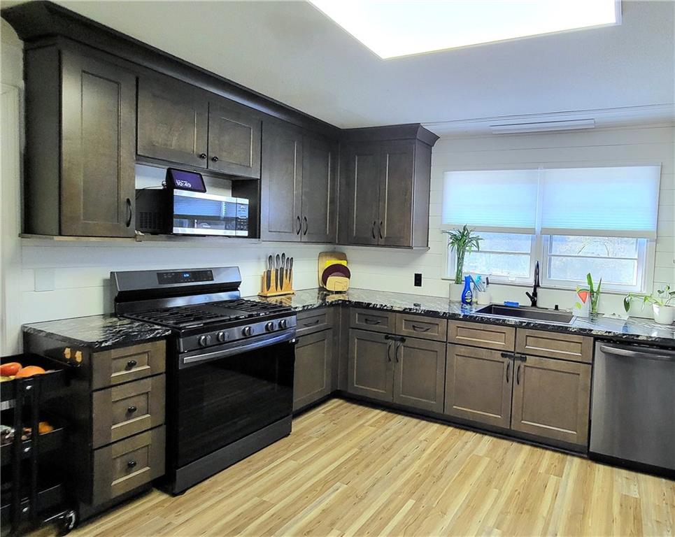 2070 Kingston Highway Rome, GA 30161 - Photo 8 of 48 a kitchen with stainless steel appliances granite countertop a stove top oven a sink dishwasher and white cabinets with wooden floor