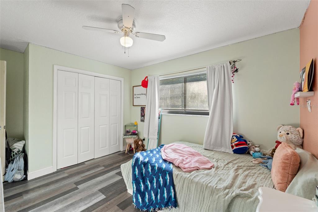 7180 Royal Oak Drive Spring Hill, FL 34607 - Photo 23 of 42 a bedroom with a bed and a chandelier