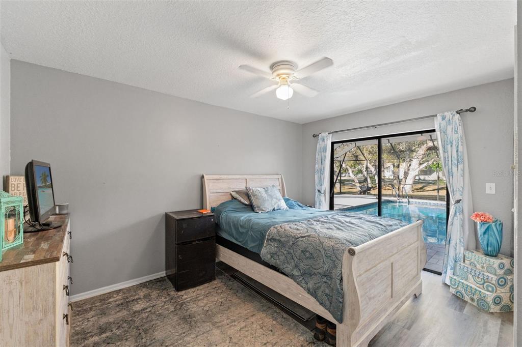 7180 Royal Oak Drive Spring Hill, FL 34607 - Photo 27 of 42 a bedroom with a bed and a chandelier