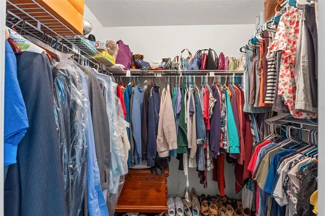 a view of walk in closet with clothes