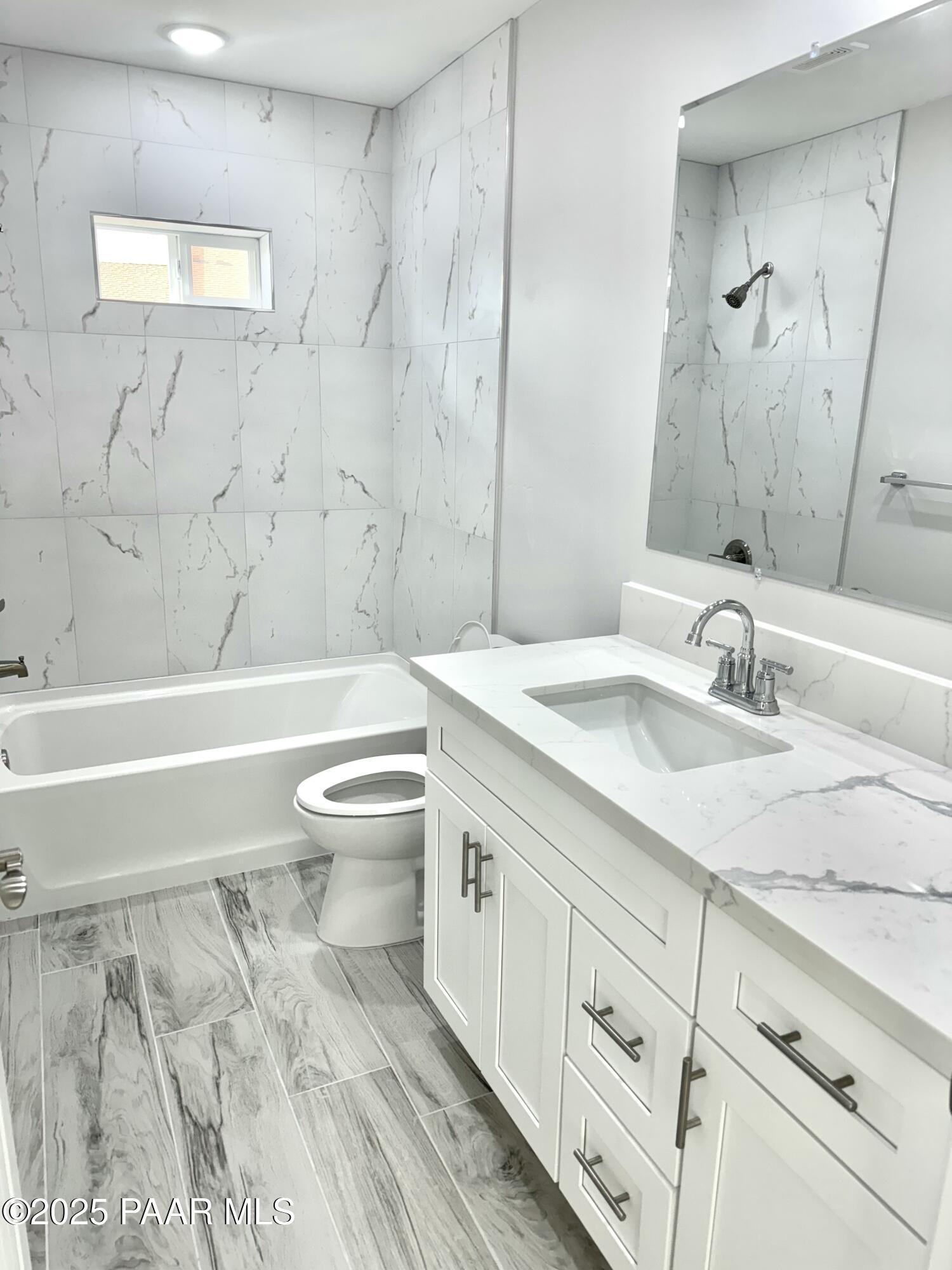 20182 East Mesa Verde Road Mayer, AZ 86333 - Photo 11 of 17 a bathroom with a granite countertop toilet a sink and a bathtub
