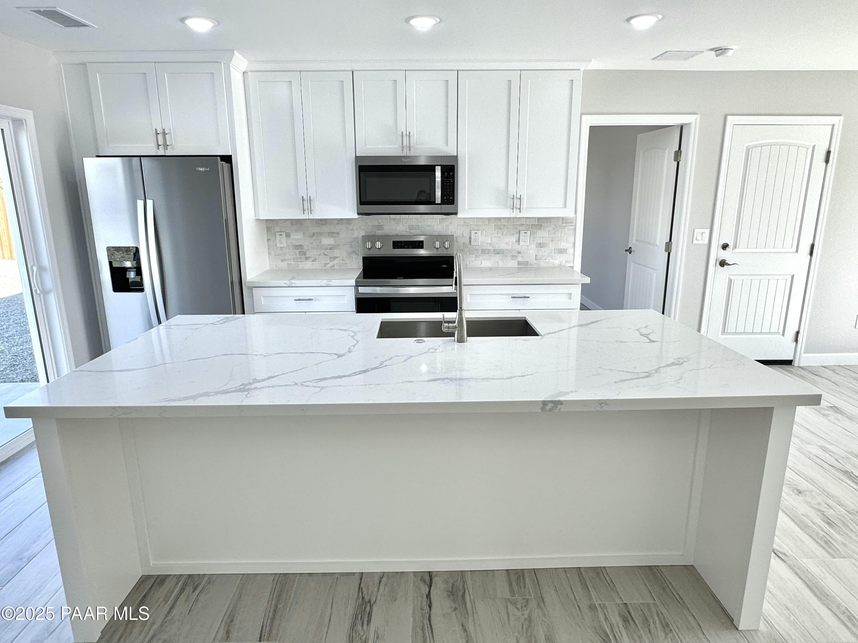 20182 East Mesa Verde Road Mayer, AZ 86333 - Photo 5 of 17 a kitchen with stainless steel appliances a microwave a sink and a refrigerator