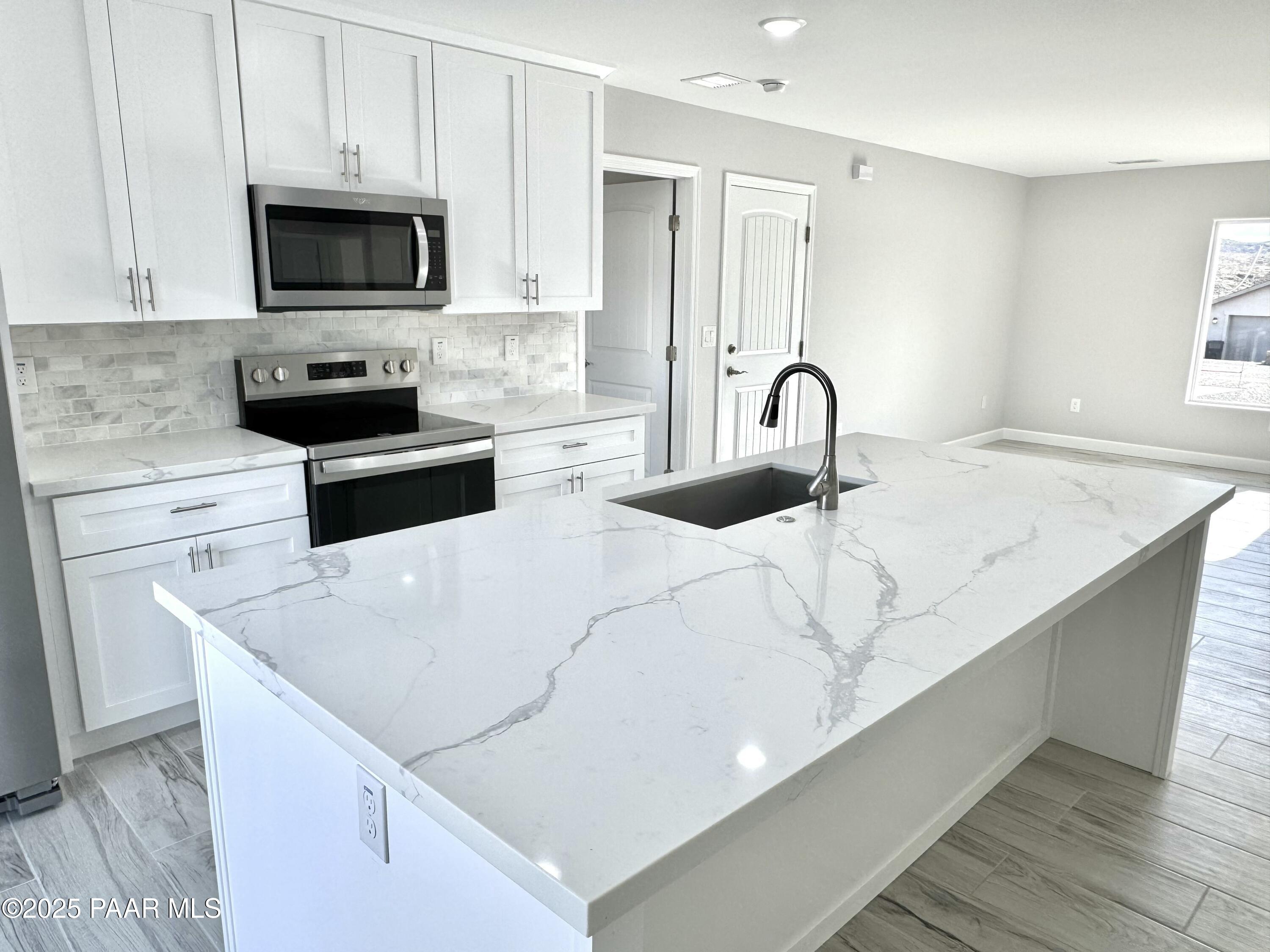 20182 East Mesa Verde Road Mayer, AZ 86333 - Photo 6 of 17 a kitchen with stainless steel appliances a stove microwave and sink