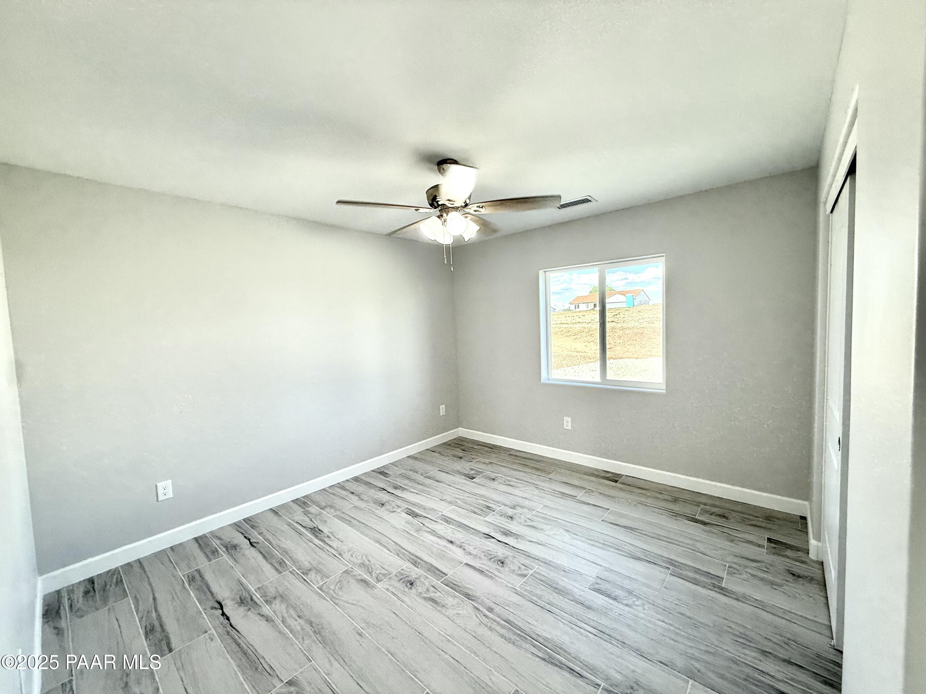 20182 East Mesa Verde Road Mayer, AZ 86333 - Photo 7 of 17 wooden floor in an empty room with a window