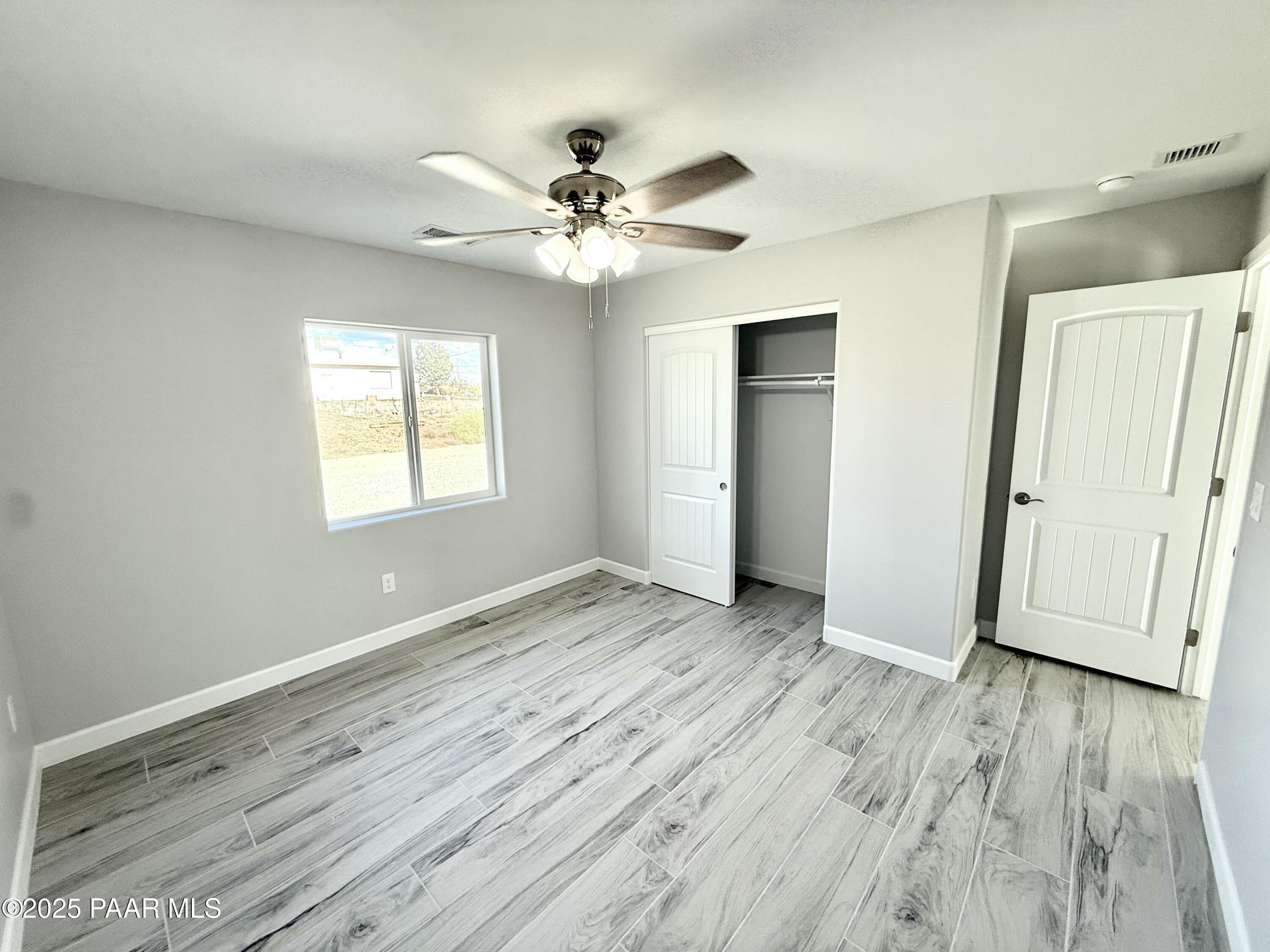 20182 East Mesa Verde Road Mayer, AZ 86333 - Photo 8 of 17 a view of an empty room with wooden floor and a window