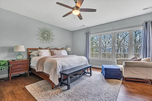 a bedroom with a bed and glass walk in closet
