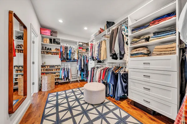 a view of walk in closet with clothes and shoes