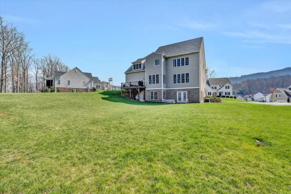a view of a house with a big yard and large trees