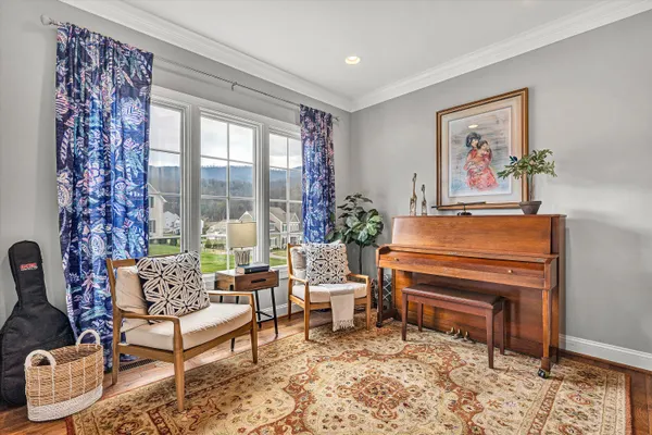 a living room with furniture and a painting on the wall