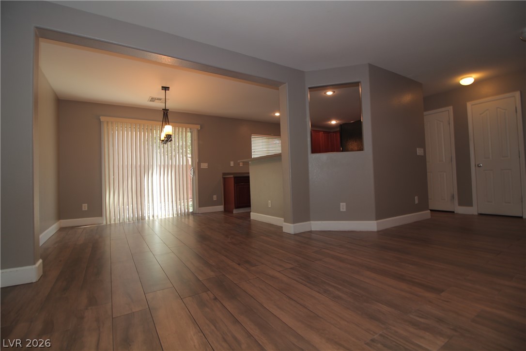 9289 Valley Ranch Avenue Las Vegas, NV 89178 - Photo 9 of 29 Natural light bathes this spacious interior, highlighting the rich wood flooring and open-concept layout.