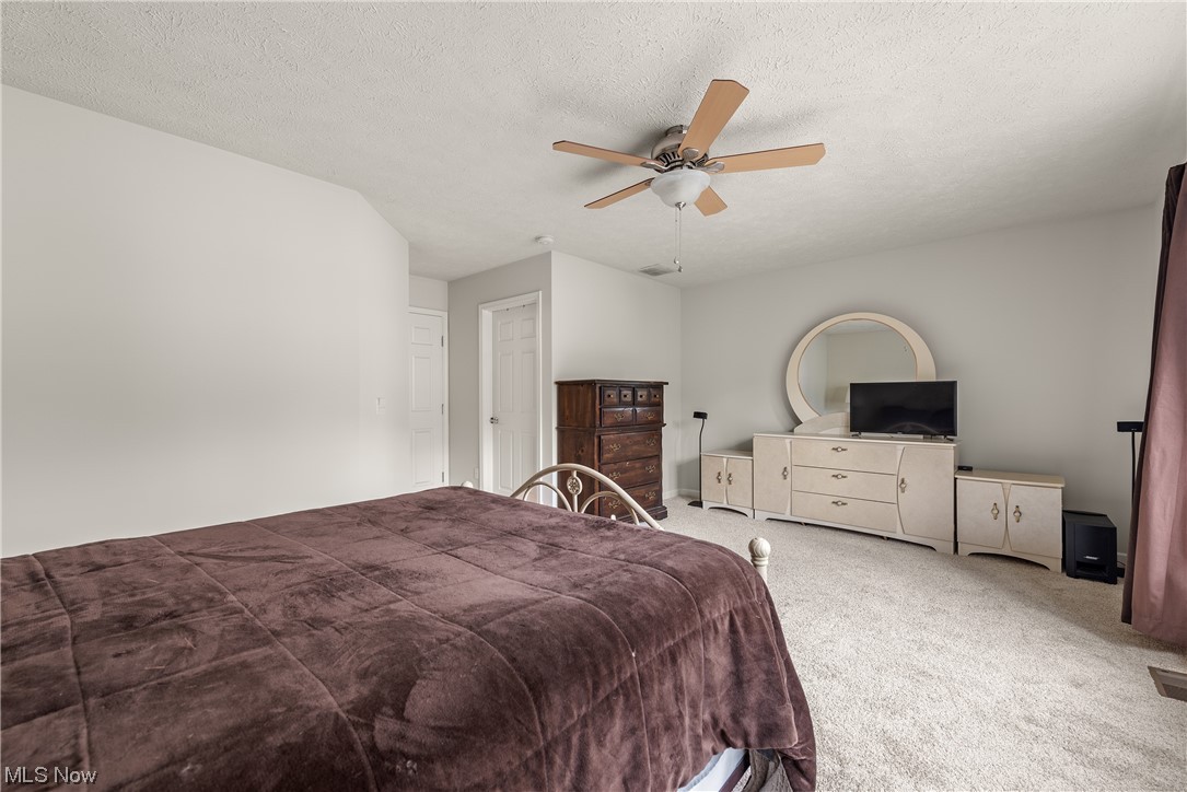 3967 Gardiner Run Akron, OH 44321 - Photo 23 of 35 Master Bedroom featuring a textured ceiling, light carpet, and ceiling fan