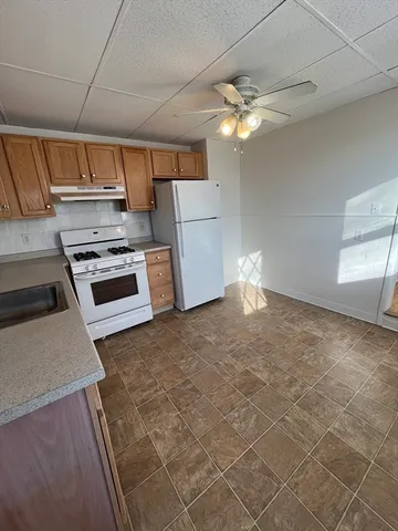 a kitchen with a stove a refrigerator and workspace