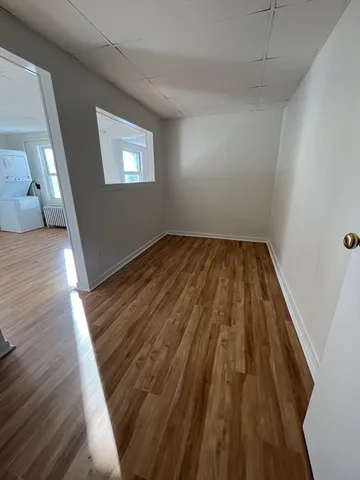 a view of a room with wooden floor and window