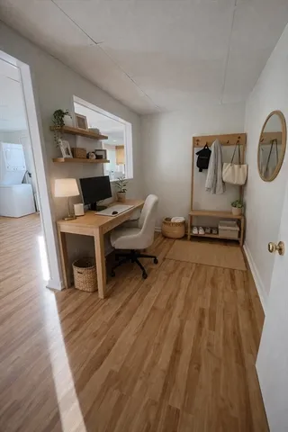 a view of a workspace with furniture and wooden floor