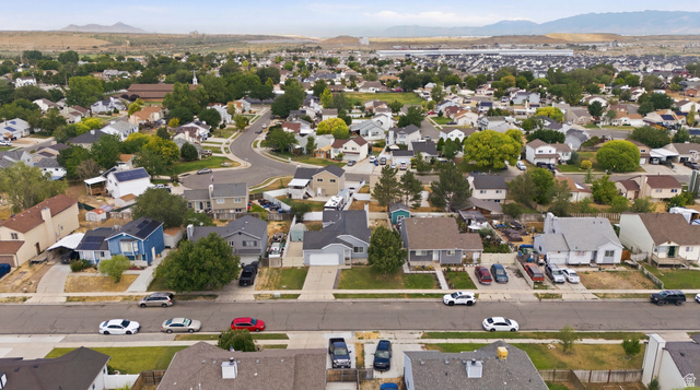 7910 Woolley Way Magna, UT 84044 - Photo 24 of 26 Expansive residential neighborhood featuring a variety of single-family homes with pitched roofs, mature trees, and paved streets