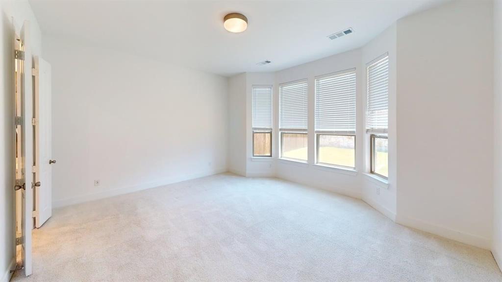 9628 Boulder Pt Road Oak Point, TX 75068 - Photo 9 of 35 Spacious room featuring a bay window with multiple panes, soft carpeting, neutral wall tones, a ceiling-mounted light fixture, and white trim