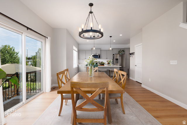 1654 South 730 West Provo, UT 84601 - Photo 8 of 33 Spacious dining area featuring wood-finish flooring, a contemporary chandelier, and large sliding glass doors providing access to an outdoor deck