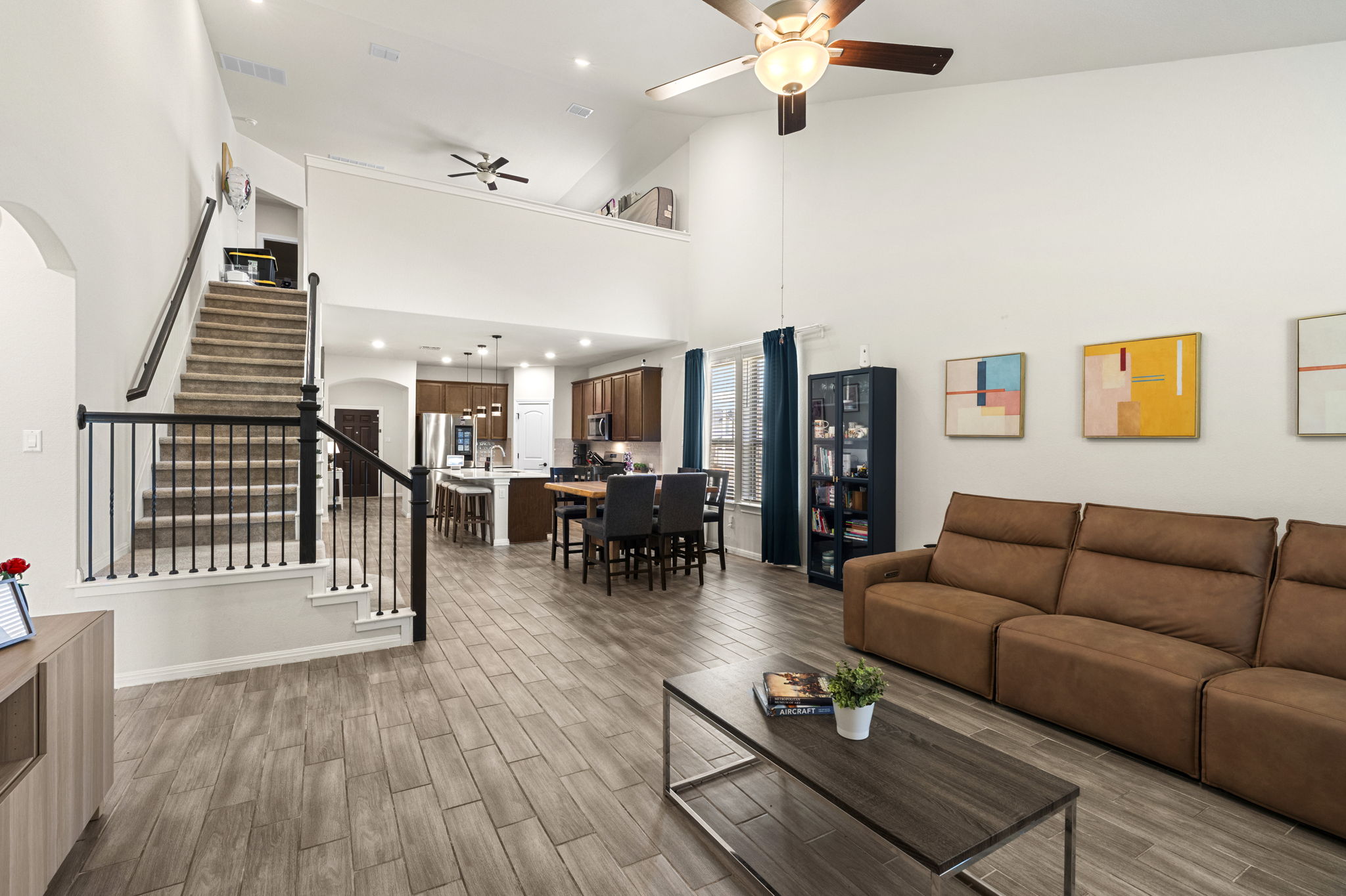 548 Purple Heart Drive Buda, TX 78610 - Photo 8 of 35 An open-concept living space with soaring ceilings and contemporary tile flooring provides an inviting atmosphere.