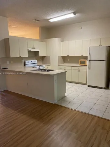 a kitchen with stainless steel appliances granite countertop a sink a stove a refrigerator and cabinets