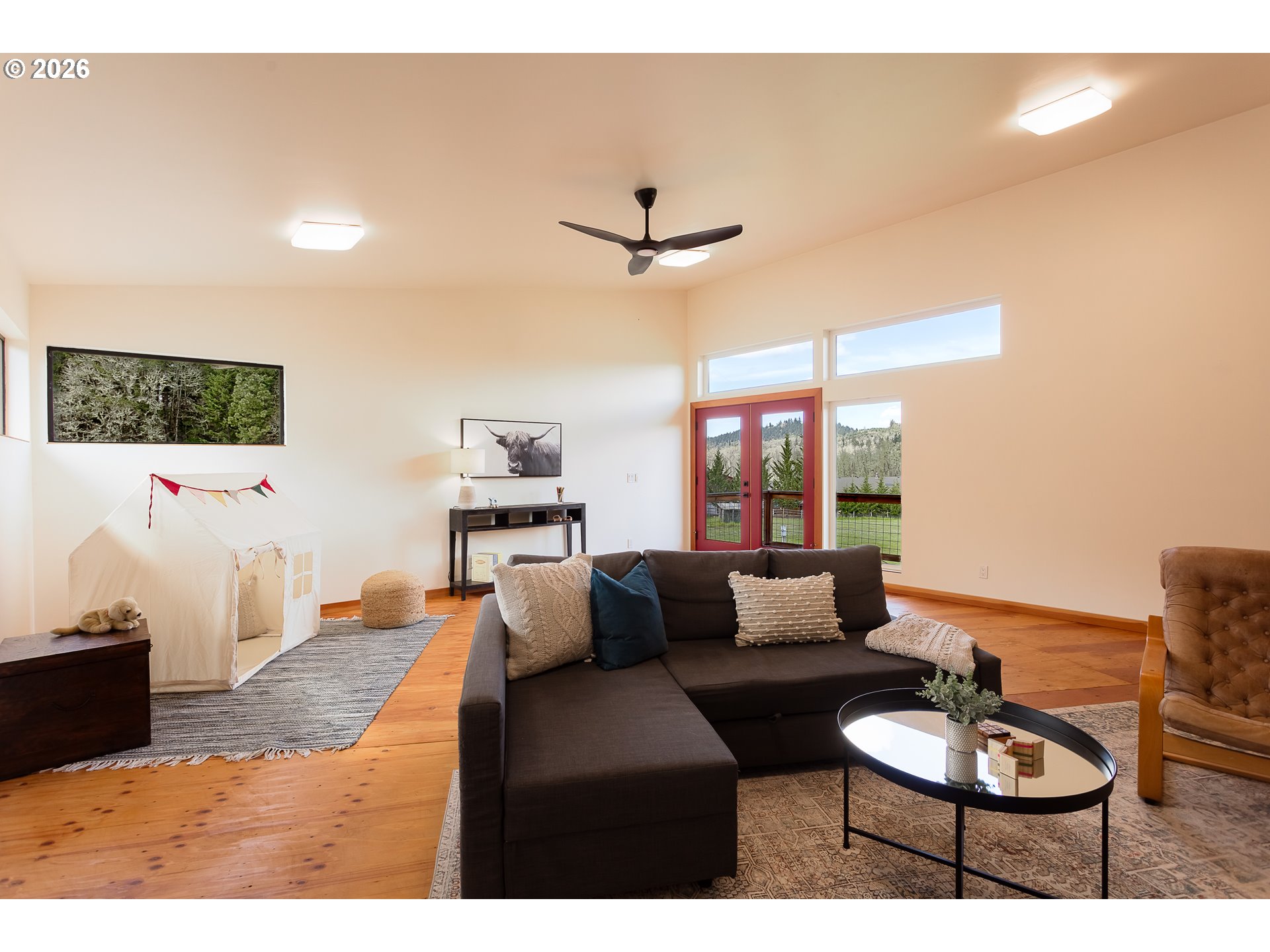 85535 Lancer Lane Eugene, OR 97405 - Photo 33 of 45 a living room with furniture a flat screen tv and a floor to ceiling window