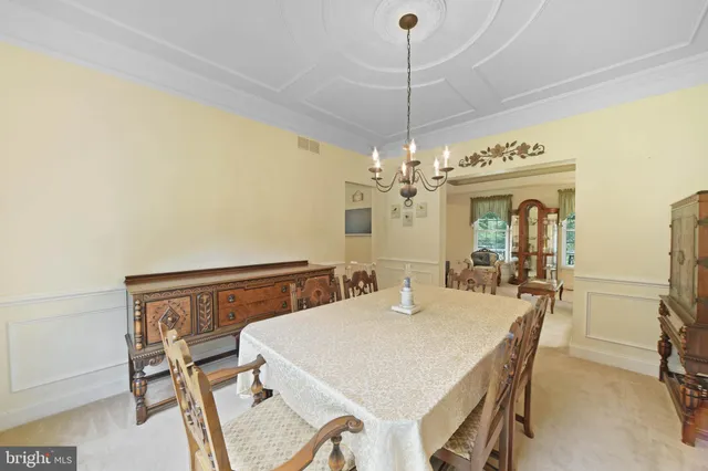 a dining room with furniture a chandelier and window