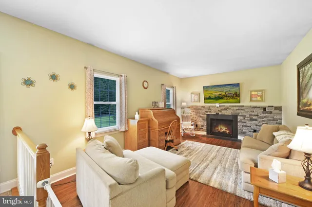 a living room with furniture a fireplace and a window