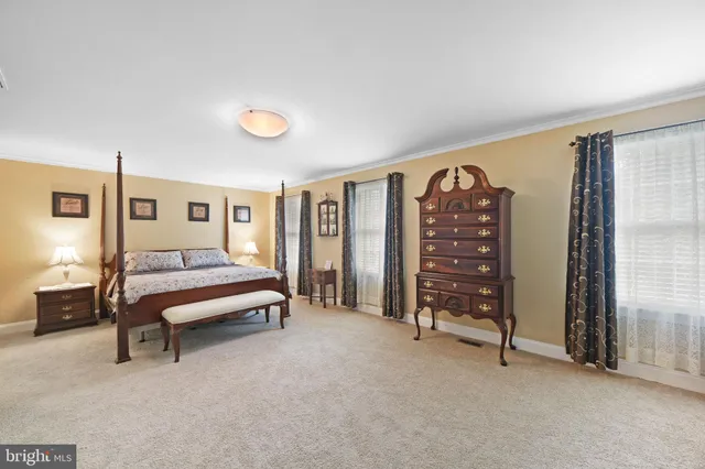 a bedroom with a bed and dresser with mirror