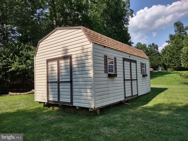 a view of a house with a big yard and large trees