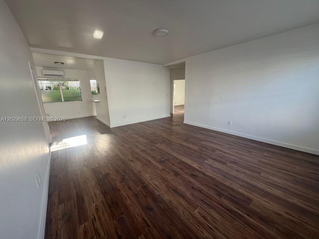 855 80th Street, Unit 4 Miami Beach, FL 33141 - Photo 6 of 16 an empty room with wooden floor and windows