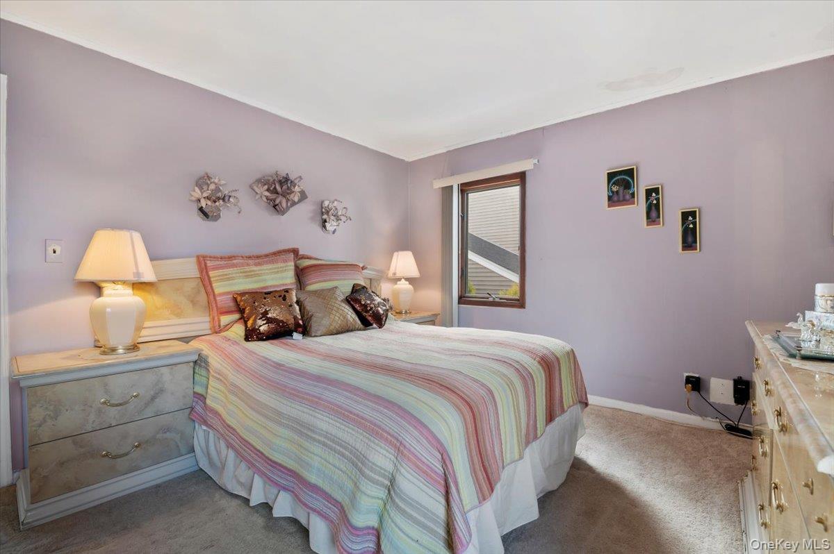 26 Bradford Lane Bethpage, NY 11714 - Photo 11 of 24 a bedroom with a bed and a lamp on dresser