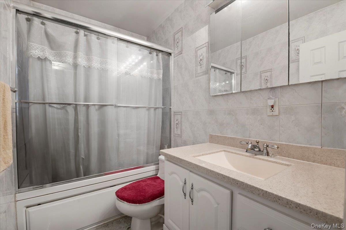 26 Bradford Lane Bethpage, NY 11714 - Photo 14 of 24 a bathroom with a sink and a mirror