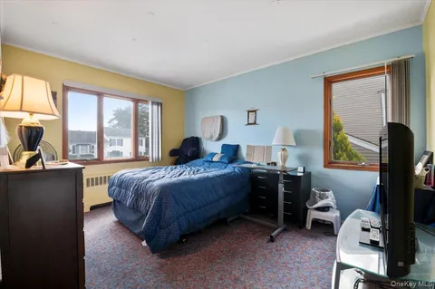 a bedroom with a bed and a flat tv screen on the dresser