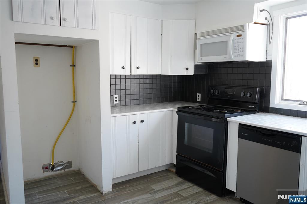 83 Roosevelt Avenue Butler, NJ 07405 - Photo 19 of 32 a kitchen with cabinets and appliances