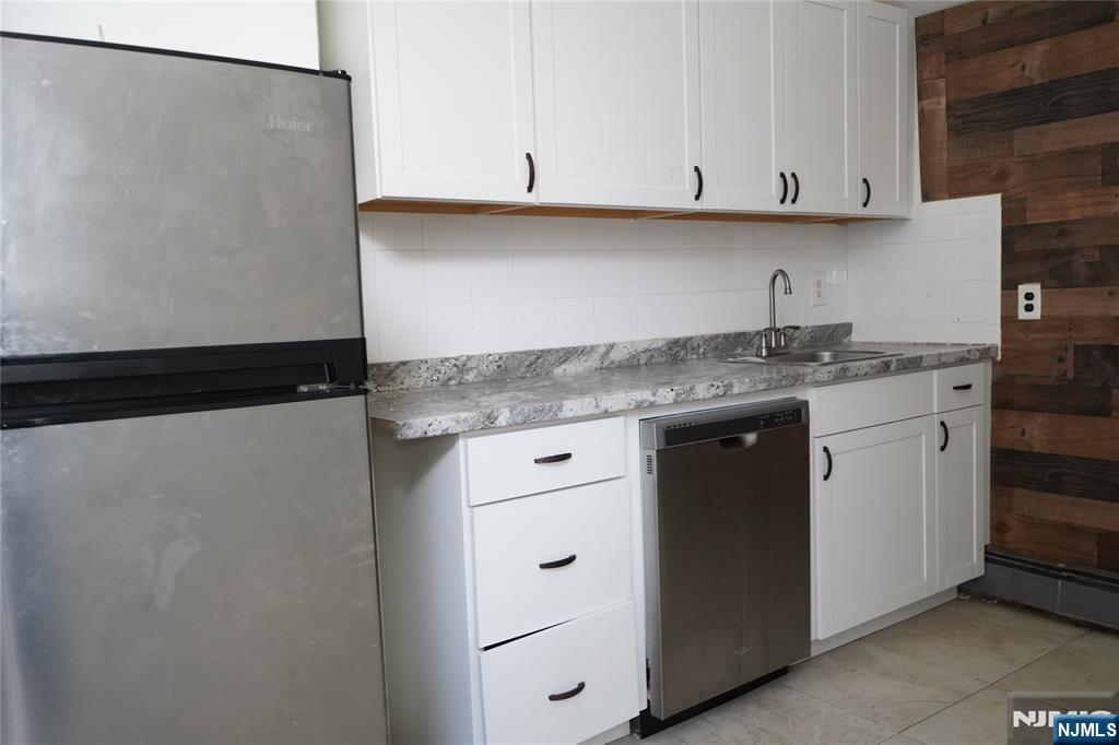 83 Roosevelt Avenue Butler, NJ 07405 - Photo 10 of 32 a kitchen with stainless steel appliances granite countertop a sink and a white cabinets
