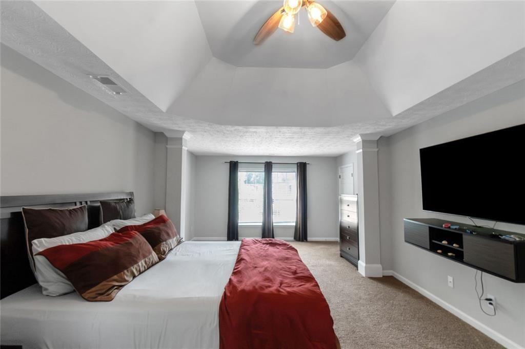 3152 Spruce Way Atlanta, GA 30349 - Photo 28 of 42 a spacious bedroom with a bed and a flat screen tv