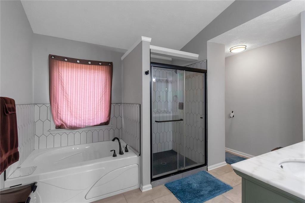 3152 Spruce Way Atlanta, GA 30349 - Photo 32 of 42 a bathroom with a tub a sink and a mirror